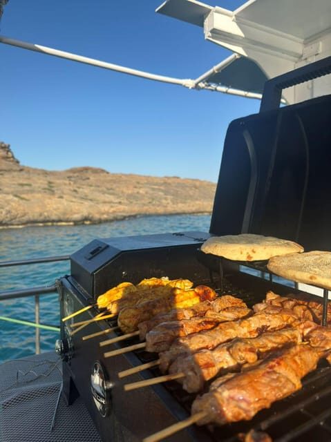 Porto Rafti: Athens Cruise Tour with Mediterranean BBQ - Porto Rafti coast views: Natura 2000, Blue Lagoon, and the Colossus of Porto Rafti